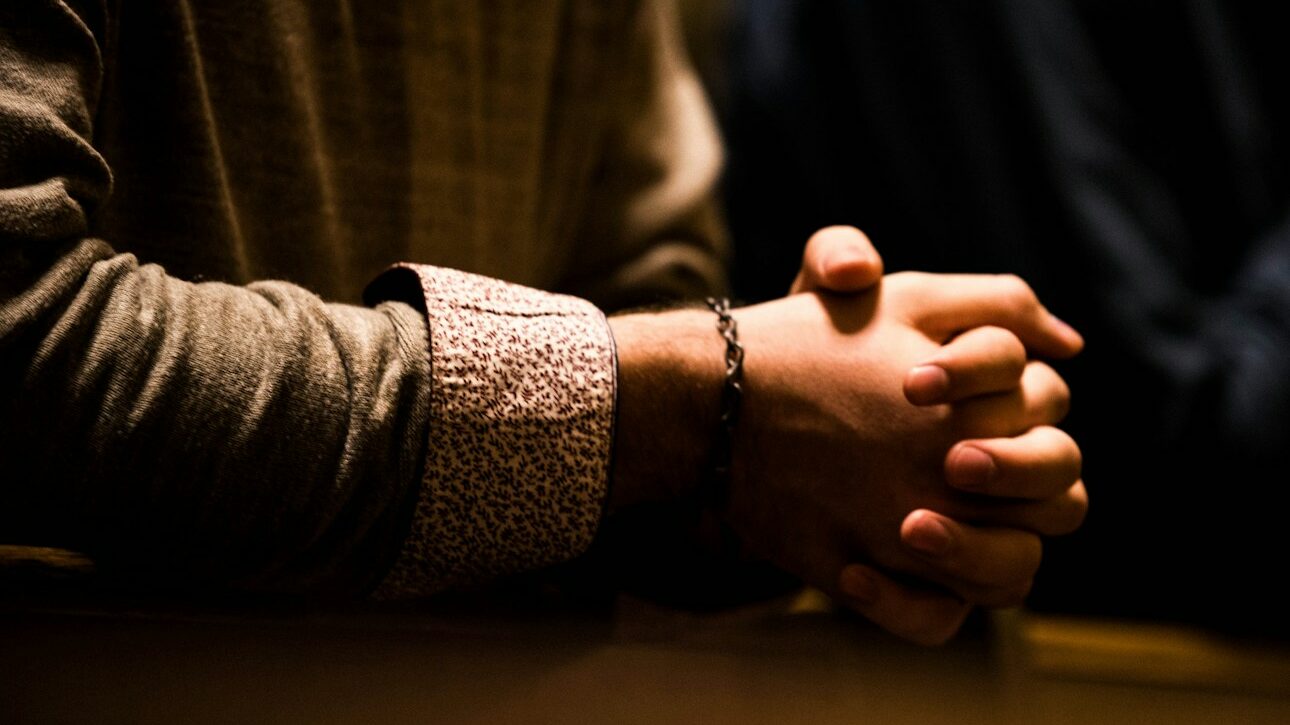 two people holding hands while sitting at a table